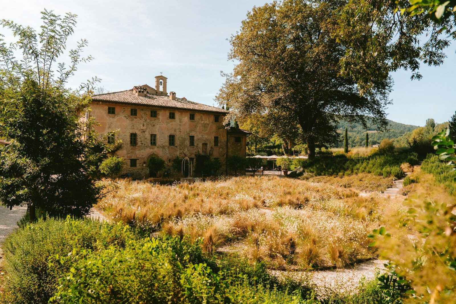 Casa de campo de piedra entre jardines y árboles