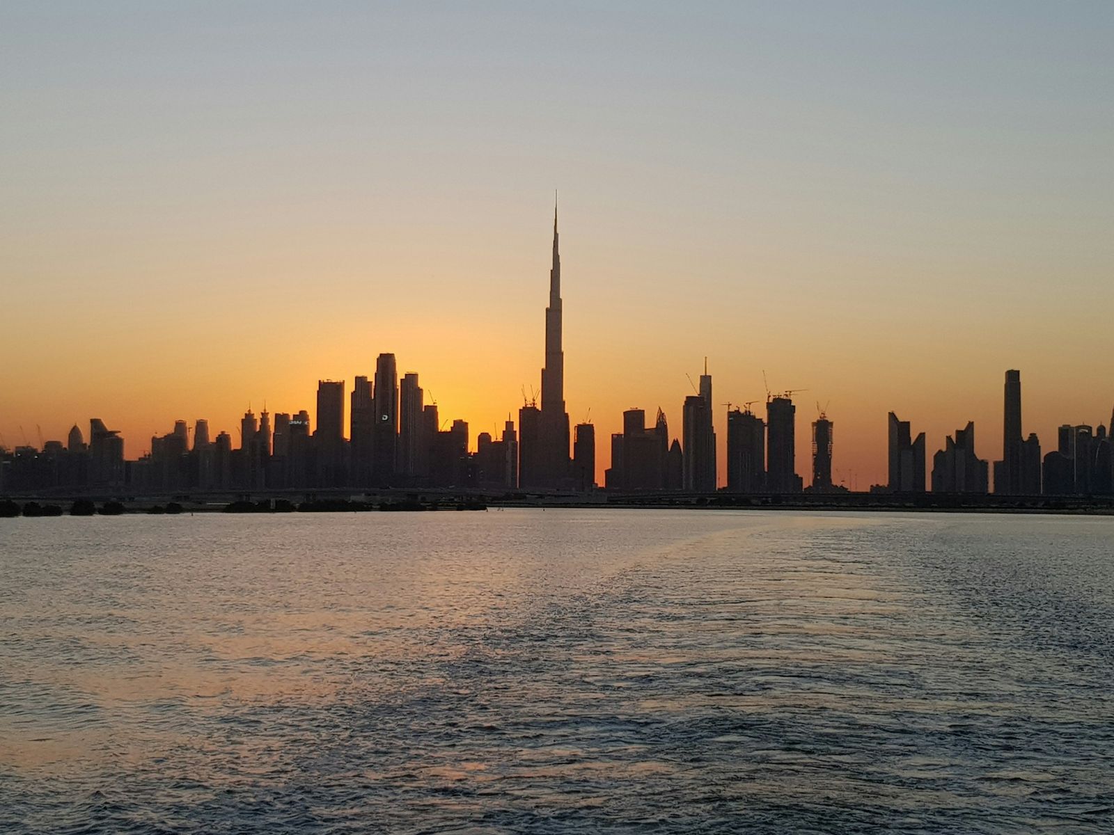 Perfil de Dubai sobre el agua al atardecer