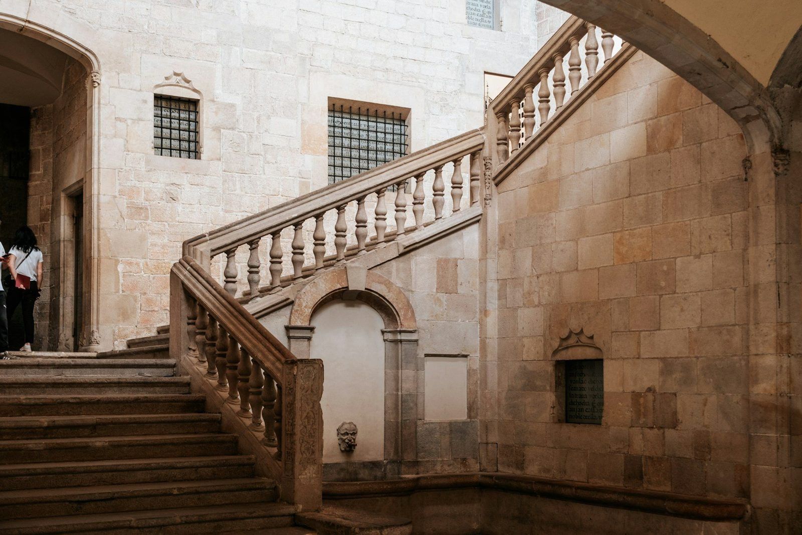 Patio gótico de piedra con una escalera de balaustrada
